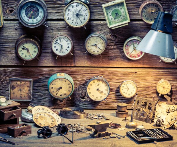 Forgotten watchmaker's workplace. Watchmaker's workplace with ruined clocks.