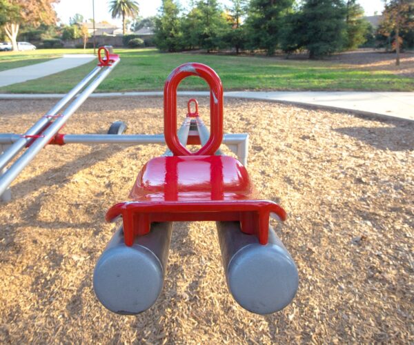 red and gray seesaw in the playground